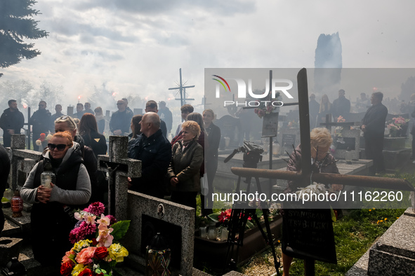 Friends fire flairs  on a cemetery as family and friends attend a funeral of Damian Sobol, a volunteer for World Central Kitchen, who was ki...