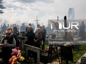 Friends fire flairs  on a cemetery as family and friends attend a funeral of Damian Sobol, a volunteer for World Central Kitchen, who was ki...