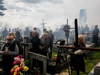 Friends fire flairs  on a cemetery as family and friends attend a funeral of Damian Sobol, a volunteer for World Central Kitchen, who was ki...