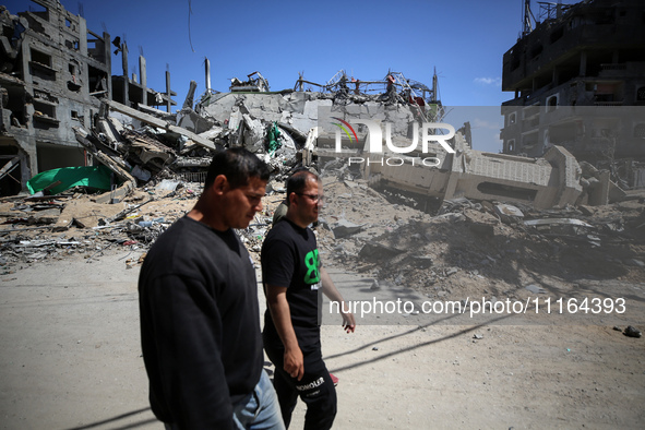 Palestinians are walking past a destroyed mosque in the city of Nuseirat in the central Gaza Strip on April 21, 2024, amid ongoing battles b...