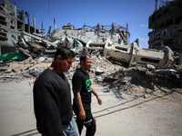 Palestinians are walking past a destroyed mosque in the city of Nuseirat in the central Gaza Strip on April 21, 2024, amid ongoing battles b...