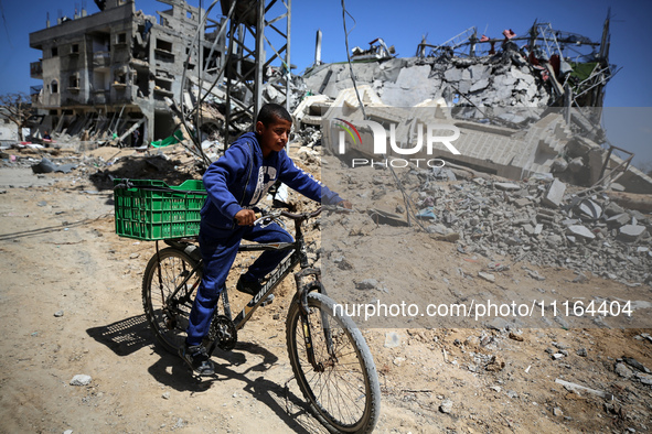 A Palestinian boy is walking past a destroyed mosque in the city of Nuseirat in the central Gaza Strip on April 21, 2024, amid ongoing battl...