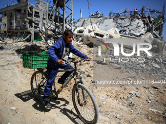 A Palestinian boy is walking past a destroyed mosque in the city of Nuseirat in the central Gaza Strip on April 21, 2024, amid ongoing battl...