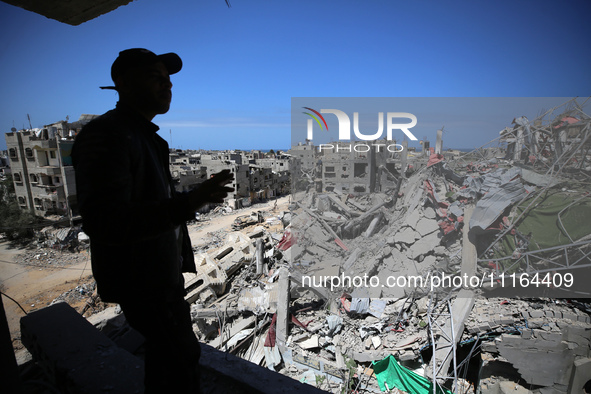 A Palestinian man is standing past a destroyed building in the city of Nuseirat in the central Gaza Strip on April 21, 2024, amid ongoing ba...