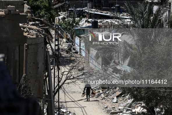 A Palestinian man is walking past a destroyed building in Nuseirat, Gaza Strip, on April 21, 2024, amid ongoing battles between Israel and t...