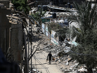 A Palestinian man is walking past a destroyed building in Nuseirat, Gaza Strip, on April 21, 2024, amid ongoing battles between Israel and t...