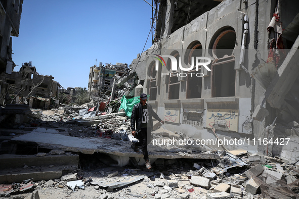 A Palestinian man is walking past a destroyed building in Nuseirat, Gaza Strip, on April 21, 2024, amid ongoing battles between Israel and t...