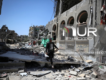 A Palestinian man is walking past a destroyed building in Nuseirat, Gaza Strip, on April 21, 2024, amid ongoing battles between Israel and t...