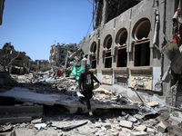 A Palestinian man is walking past a destroyed building in Nuseirat, Gaza Strip, on April 21, 2024, amid ongoing battles between Israel and t...