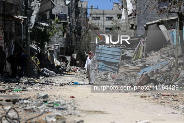 A Palestinian man is walking past a destroyed building in Nuseirat, Gaza Strip, on April 21, 2024, amid ongoing battles between Israel and t...