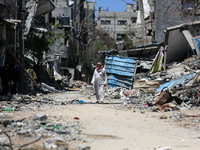 A Palestinian man is walking past a destroyed building in Nuseirat, Gaza Strip, on April 21, 2024, amid ongoing battles between Israel and t...