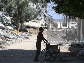 A Palestinian boy is standing past a destroyed mosque in the city of Nuseirat in the central Gaza Strip on April 21, 2024, amid ongoing batt...