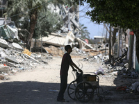 A Palestinian boy is standing past a destroyed mosque in the city of Nuseirat in the central Gaza Strip on April 21, 2024, amid ongoing batt...