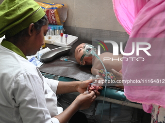 A child is receiving medical treatment for pneumonia at Dhaka Child Hospital amid an ongoing heatwave in Dhaka, Bangladesh, on April 21, 202...