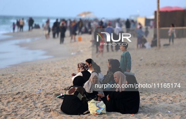 Palestinians are enjoying the beach on a hot day amid the ongoing conflict between Israel and Hamas in Deir Al-Balah, in the central Gaza St...