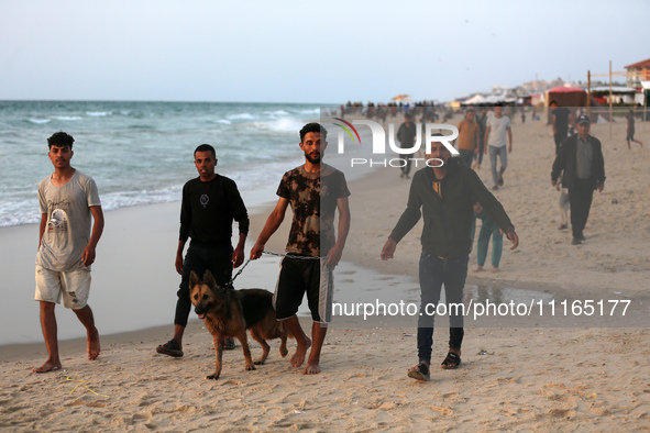 Palestinians are enjoying the beach on a hot day amid the ongoing conflict between Israel and Hamas in Deir Al-Balah, in the central Gaza St...