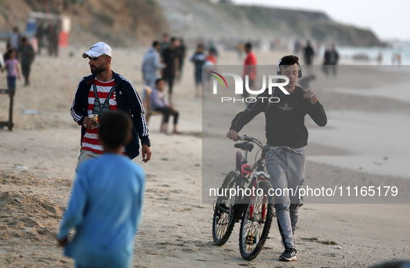 Palestinians are enjoying the beach on a hot day amid the ongoing conflict between Israel and Hamas in Deir Al-Balah, in the central Gaza St...