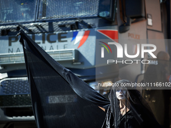 A Black Rebel from XR is standing in front of a police water cannon. Several thousand people are demonstrating in the streets of Toulouse, F...