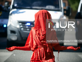 A Red Rebel from Extinction Rebellion is standing in front of riot police in Toulouse, France, on April 21, 2024. Several thousand people ar...