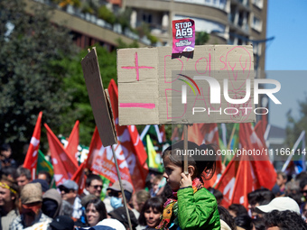 A young girl is holding a placard that reads 'More birds, less highways' as several thousand people are demonstrating in the streets of Toul...