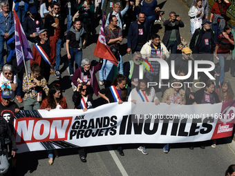 Members of La France Insoumise (France Unbowed) are holding a banner that reads 'Stop to big useless projects'. Several thousand people are...