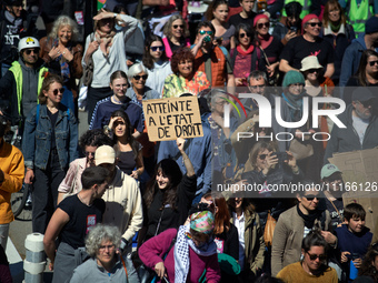 A woman is holding a cardboard sign that reads 'Breach of rule of law'. Several thousand people are demonstrating in the streets of Toulouse...