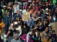 A woman is holding a cardboard sign that reads 'Breach of rule of law'. Several thousand people are demonstrating in the streets of Toulouse...