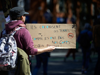 Protesters are holding placards, one of which reads 'They colonize lands as they colonized our bodies, ZAD, everywhere,' as they demonstrate...