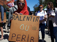 A protester is displaying a cardboard sign with the message ''to slow down or to die'' as several thousand people are demonstrating in the s...