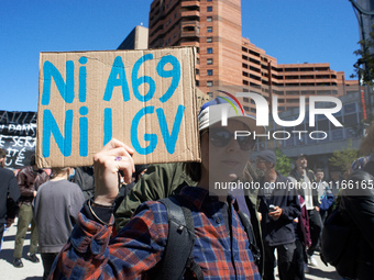 A young woman is holding a placard that reads 'Nor A69, nor LGV'. Several thousand people are demonstrating in the streets of Toulouse, Fran...