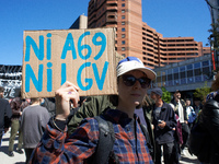 A young woman is holding a placard that reads 'Nor A69, nor LGV'. Several thousand people are demonstrating in the streets of Toulouse, Fran...