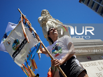 A man is standing near the statue of Pierre-Paul Riquet in Toulouse, holding a flag that reads 'La Voie Est Libre'. Several thousand people...