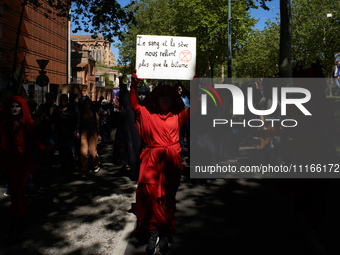 A Red Rebel from Extinction Rebellion is holding a placard that reads, ''Blood and sap connect us more than asphalt.'' Several thousand peop...