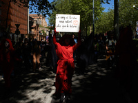 A Red Rebel from Extinction Rebellion is holding a placard that reads, ''Blood and sap connect us more than asphalt.'' Several thousand peop...