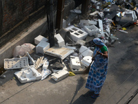 A daily wage worker is cleaning the road where household garbage and waste have been thrown at the roadside area in Siliguri, India, on Apri...