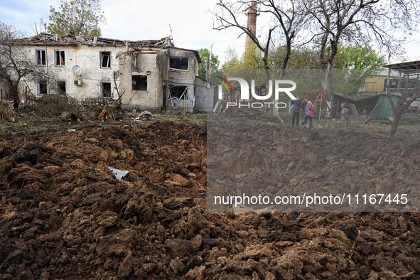 A crater from the debris of a Russian missile is being seen in a residential area in the Odesa Region, Southern Ukraine, on April 21, 2024....