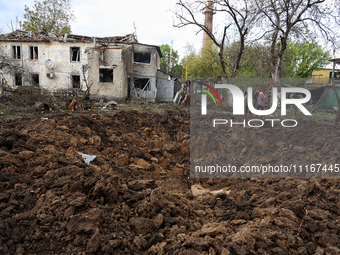 A crater from the debris of a Russian missile is being seen in a residential area in the Odesa Region, Southern Ukraine, on April 21, 2024....