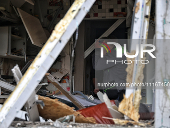 A man is pressing his hand to his forehead in a kitchen that has been damaged by a Russian missile attack in the Odesa region, southern Ukra...