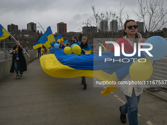 EDMONTON, CANADA - APRIL 21, 2024:
Members of the Ukrainian diaspora proudly wave national flags, hold blue and yellow balloons, and display...