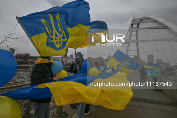 EDMONTON, CANADA - APRIL 21, 2024:
Members of the Ukrainian diaspora proudly wave national flags, hold blue and yellow balloons, and display...