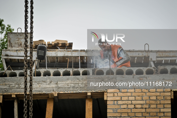 Workers are reconstructing a residential building damaged by a Russian missile strike on the night of March 2, 2023, at 67 Nezalezhnoyi Ukra...