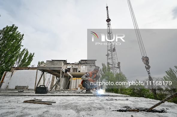 Workers are reconstructing a residential building damaged by a Russian missile strike on the night of March 2, 2023, at 67 Nezalezhnoyi Ukra...