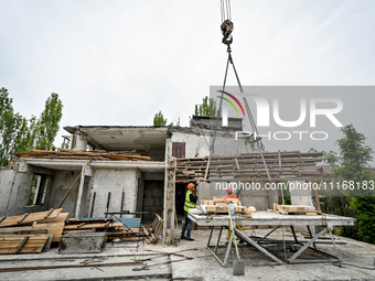 Workers are reconstructing a residential building damaged by a Russian missile strike on the night of March 2, 2023, at 67 Nezalezhnoyi Ukra...