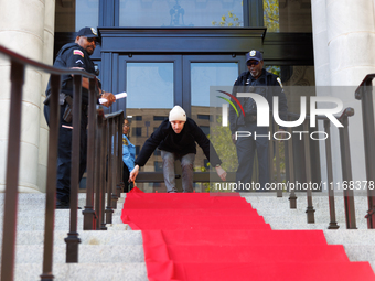 Police watch as a climate activist with the Extinction Rebellion DC organization rolls out a red carpet for Mayor Muriel Bowser during a pro...