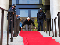 Police watch as a climate activist with the Extinction Rebellion DC organization rolls out a red carpet for Mayor Muriel Bowser during a pro...