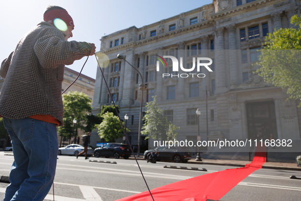 Climate activists with the Extinction Rebellion DC organization roll out a red carpet for Mayor Muriel Bowser during a protest outside of th...