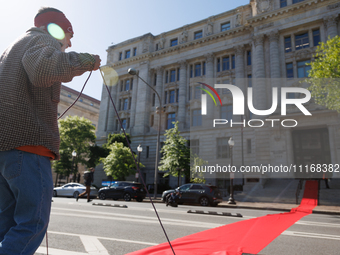 Climate activists with the Extinction Rebellion DC organization roll out a red carpet for Mayor Muriel Bowser during a protest outside of th...