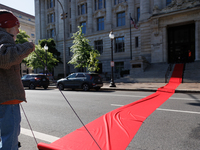 Climate activists with the Extinction Rebellion DC organization roll out a red carpet for Mayor Muriel Bowser during a protest outside of th...