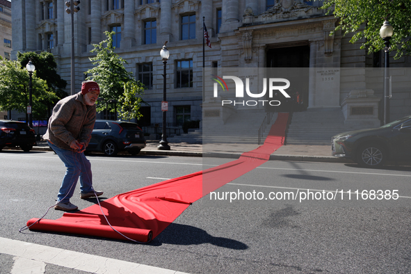 Climate activists with the Extinction Rebellion DC organization roll out a red carpet for Mayor Muriel Bowser during a protest outside of th...