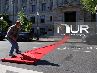 Climate activists with the Extinction Rebellion DC organization roll out a red carpet for Mayor Muriel Bowser during a protest outside of th...